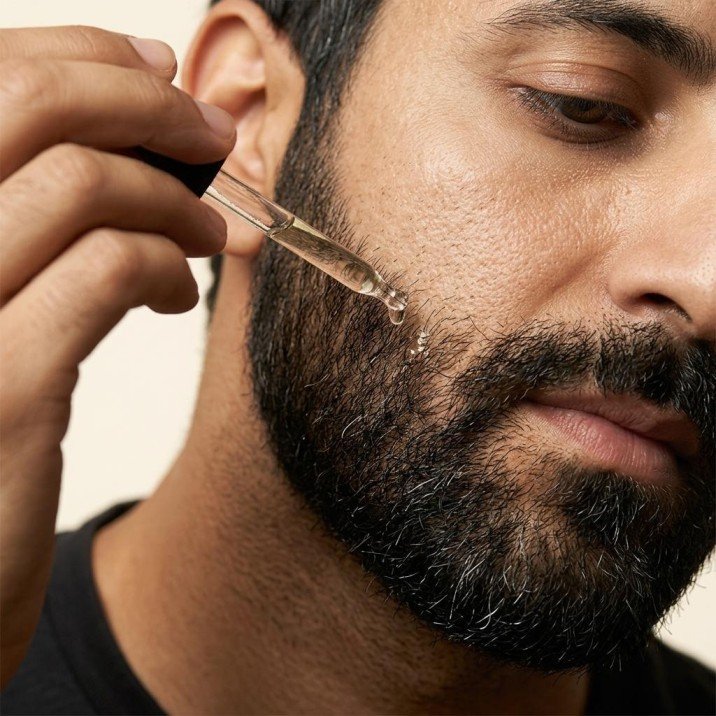 Men applying beard oil
